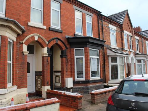 a row of brick houses with a car parked in front at Townhouse PLUS @ 282 Walthall Street in Crewe