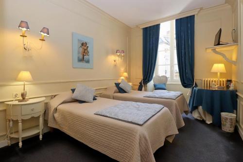 ein Hotelzimmer mit 2 Betten und einem Fenster in der Unterkunft Le Pavillon Saint-Martin in Souillac