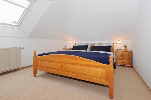 a bedroom with a wooden bed and a window at Ferienwohnung im Haus Solea in Esens