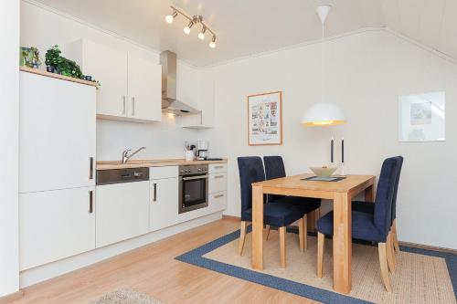 a kitchen and dining room with a wooden table and chairs at Ferienwohnung im Haus Solea in Esens
