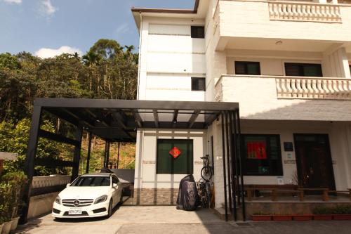 een witte auto geparkeerd voor een huis bij Zhen Guesthouse in Yuanshan