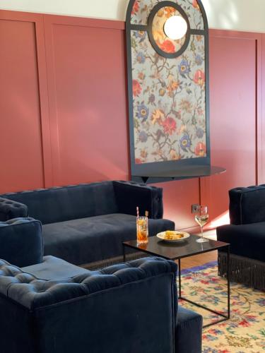 a living room with blue couches and a large window at Best Western Porte du Forez in Andrézieux-Bouthéon