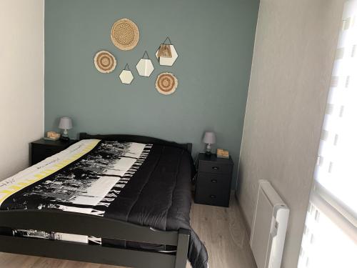 a bedroom with a bed with a black comforter at Appartement vue sur mer in Talmont