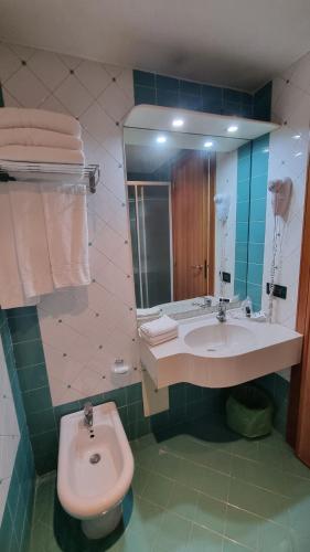 a bathroom with a sink and a toilet and a mirror at HOTEL QUADRIFOGLIO in Pomigliano dʼArco
