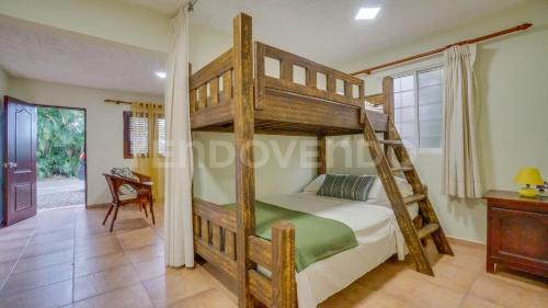 una camera da letto con un letto a castello in legno con una scala di El Yaguacil villa a Jarabacoa