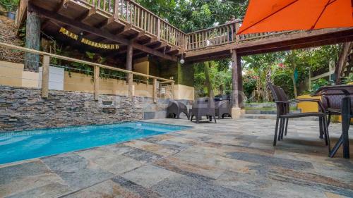 patio con ombrellone e piscina di El Yaguacil villa a Jarabacoa