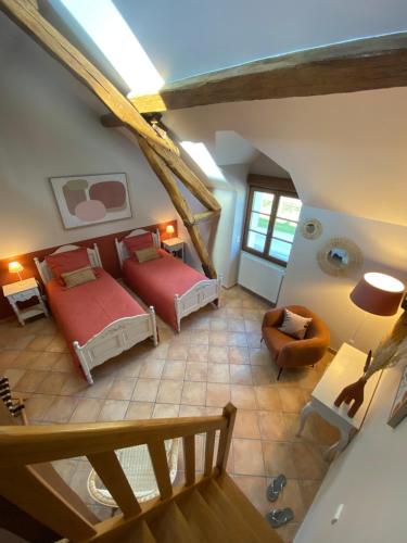 Cette chambre mansardée comprend deux lits et un canapé. dans l'établissement La Ferme de Fontenelle, à Amillis
