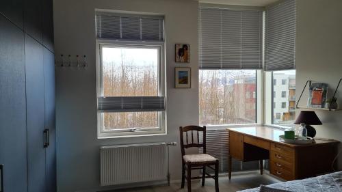 una camera da letto con scrivania e 2 finestre di Bjarkarholt 25 a Mosfellsbær