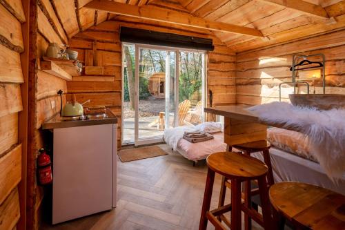 a log cabin with a kitchen and a bedroom at ZEN-Bungalow NO 3 met sauna en hottub in Rheezerveen