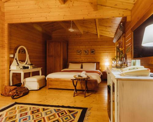 una camera da letto con un letto in una cabina di legno di Mountain Breeze Lodge & Resort ad Al-Salṭ