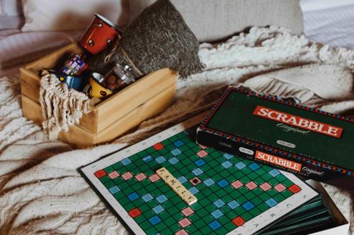 a board game and other toys on a bed at Mountain Breeze Lodge & Resort in Al Salt