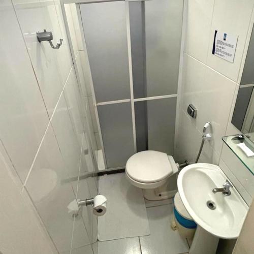 a bathroom with a shower and a toilet and a sink at Pousada Kopenhagen Beach in Cabo Frio