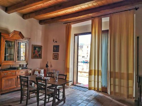 a dining room with a table and a large window at Bosa Exclusive Apartments "Bosa Apartments" in Bosa