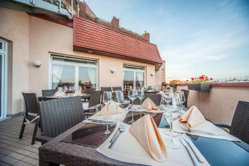 a restaurant with tables and chairs on a patio at Sky Business Hotel in Legnica