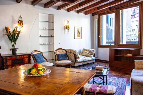 a living room with a wooden table with a bowl of fruit at La Terrazza di San Marco - Luxury Apartment in Venice