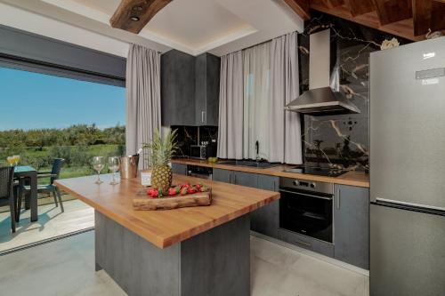 a kitchen with a island with a pineapple on it at Azor Luxury Villa I in Mouzákion