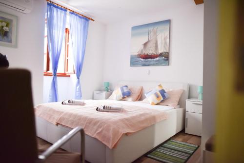 a bedroom with a large bed with blue curtains at Luka's amber rooms in the center of Trogir in Trogir