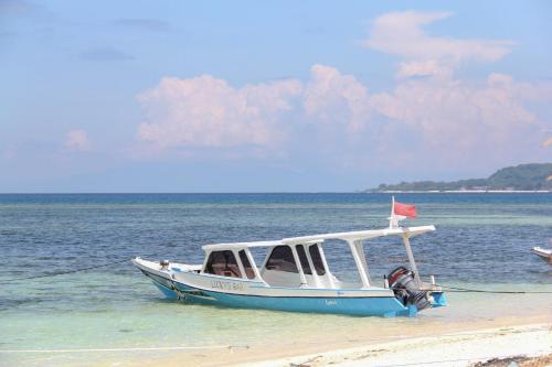 a boat sitting on the beach in the water at LUCKY'S in Gili Air