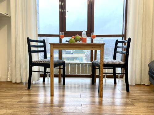 阿拉木圖的住宿－Апартаменты #3，一张桌子,上面有两把椅子和一碗水果