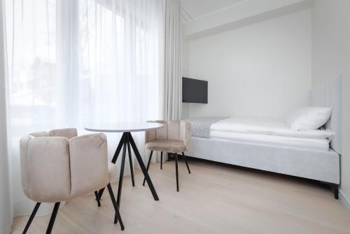 a bedroom with a bed and a table and chairs at Valli Residence in Tartu