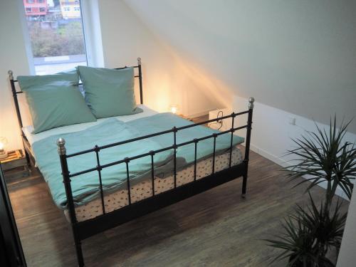 een slaapkamer met een bed met blauwe lakens en een raam bij Kaffeevollautomat, Hängematte & Netflix, zentral in Idar-Oberstein