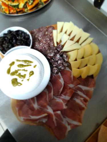 a plate of food with meats and cheese and dips at Agriturismo la stragola in Nicosia