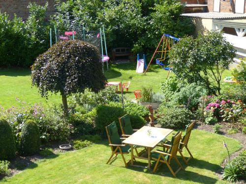 a table and chairs in a garden with a playground at Landhaus Bolzum in Sehnde