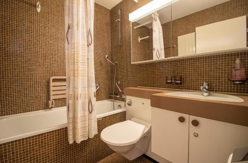 e bagno con servizi igienici, lavandino e vasca. di Rehwiesa B24 by Arosa Holiday a Arosa
