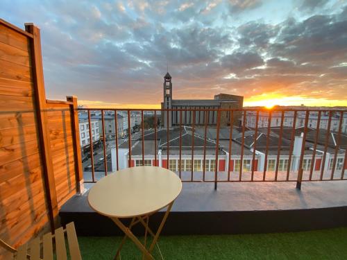 a balcony with a table and a clock tower at Hotel Saint Louis in Brest
