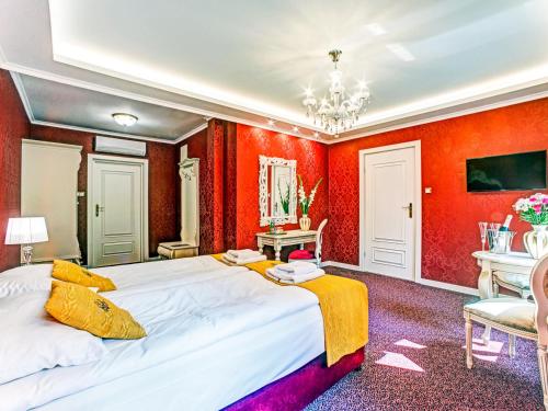 een slaapkamer met rode muren en een groot bed bij ROYAL PALACE Centrum Bankietowe in Sanok