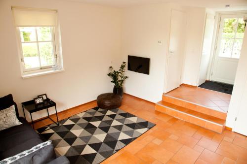 a living room with a couch and a checkered floor at Het Eerste Huisje vacation home in Noordwijk aan Zee