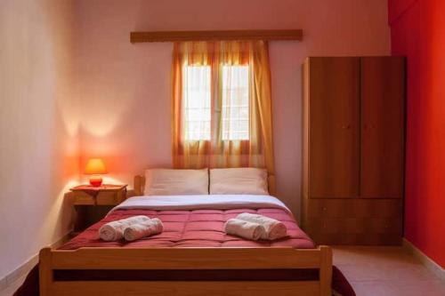 a bedroom with a large bed with a window at Pink house in Drepana