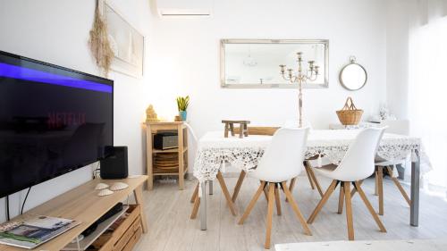 a living room with a table and white chairs at Villa O Canto da Parra - Hot Jacuzzi - Swimming Pool - WIFI - BY BEDZY in Galé