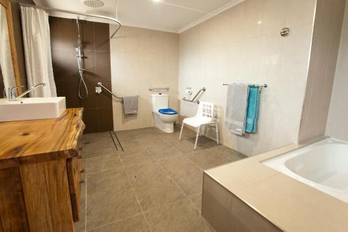 a bathroom with a toilet and a sink and a tub at Stirling Estate Chalets in Capel