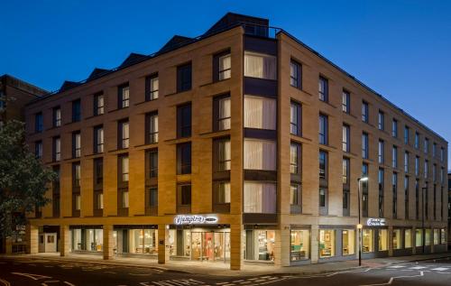 a large brick building on a street at night at Hampton By Hilton Bath City in Bath