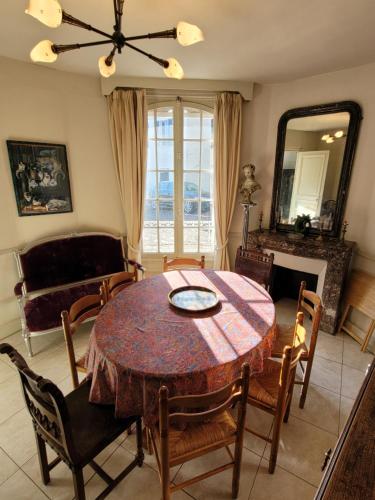 een eetkamer met een tafel en stoelen en een spiegel bij La Falaise in Saint-Valery-sur-Somme