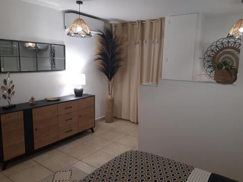 a living room with a dresser and a potted plant at La Romarine in Le Gosier