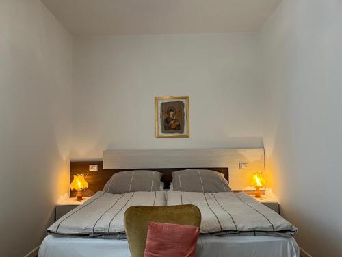 a bedroom with a large bed with two chairs at Haus Romagnoli Residence in Lazise