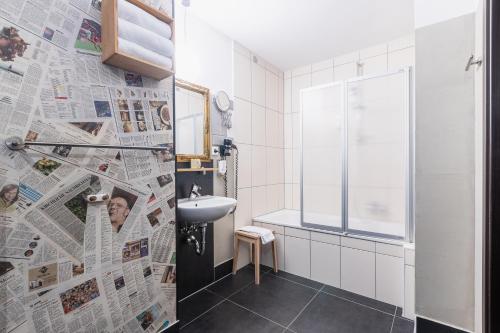 uma casa de banho com um jornal na parede em Aappartel City Center - kontaktloser Check-in 24h em Bielefeld