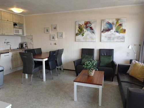 a living room with a table and chairs and a kitchen at DUINZICHT 8 Bed by the Sea in Westkapelle