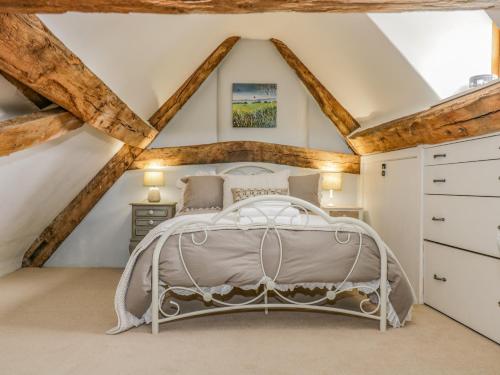a bedroom with a bed in a attic at Fox Den Cottage in Castle Combe
