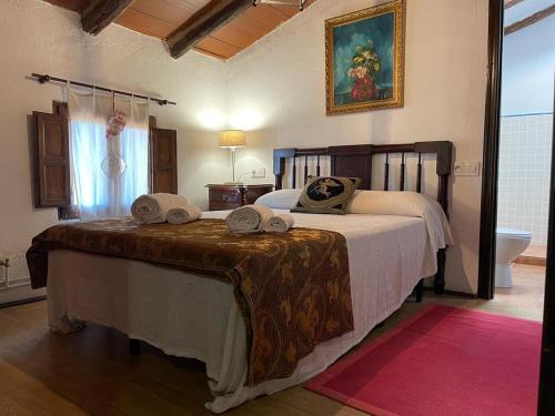 CASA RURAL VICENTA 1750 في Albentosa: غرفة نوم بها سرير وعليه قبعتين