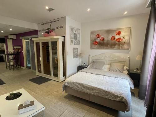 1 dormitorio con 1 cama y 1 mesa en Appart' Spa et Sauna Privatif Au Cœur De Beaune en Beaune