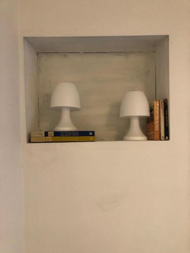 two lamps sitting on a shelf with books at Best location ! Apt privado 2 hab con AC Completamente equipado en Asuncion in Asuncion