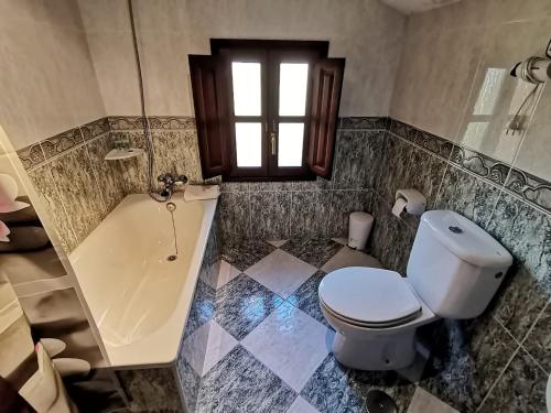 a bathroom with a toilet and a bath tub at Valle la Fuente in El Escobal