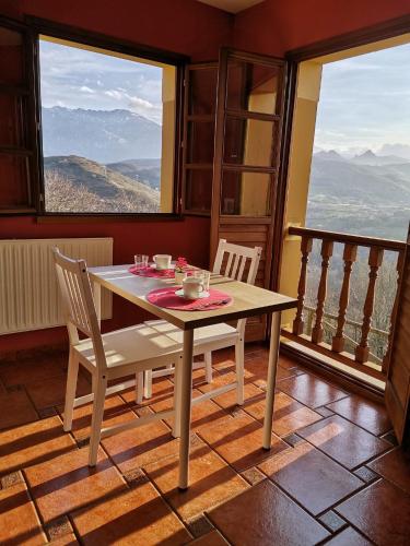 a table and chairs in a room with a balcony at Valle la Fuente in El Escobal