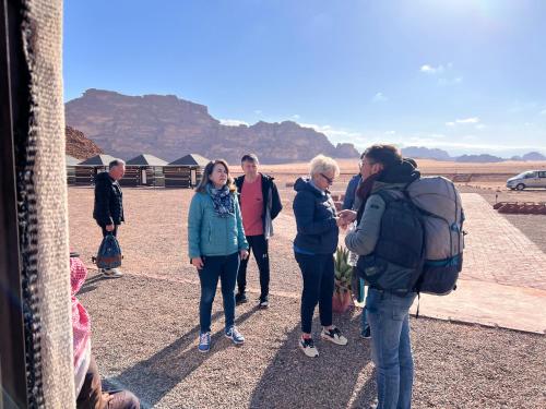 a group of people standing on the side of a bus at Shakria Bedouin Life Camp in Wadi Rum