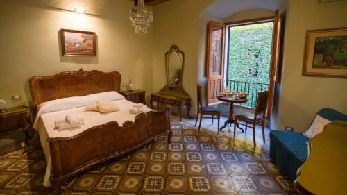 a bedroom with a bed and a chair and a window at Welcomely - Residenza Deriu in Bosa