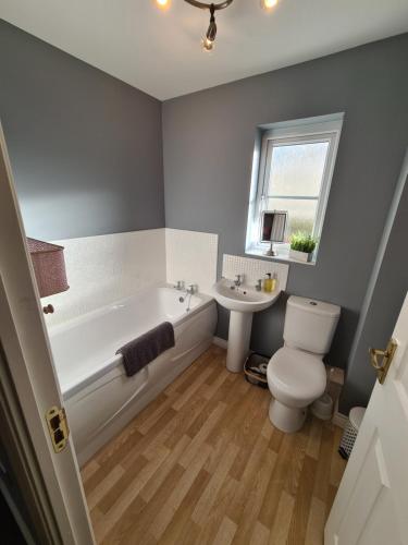 a bathroom with a tub and a toilet and a sink at Delightful 3 bed house nr the centre of Cheltenham in Cheltenham