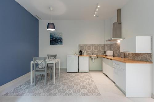 cocina con armarios blancos, mesa y sillas en Sunny,Private Terrace,Wheelchair access en Valencia